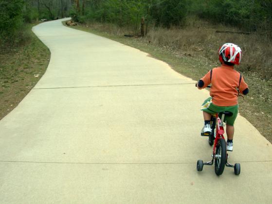 A Kid Riding Bicycle on Branchwood Walking Trail