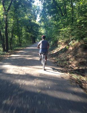 A Man Cycling on the Trail